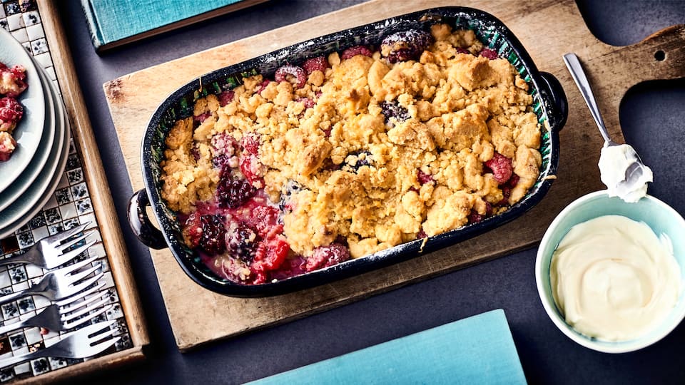 Bei diesem Dessert werden Frucht und Teig "zusammengeflickt": Probieren Sie unseren leckeren Himbeer-Brombeer-Cobbler aus dem Ofen mit Zimt, Puderzucker, Sahnecreme und Crème fraiche!