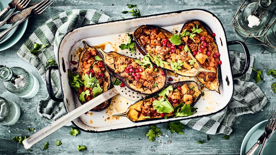 Gefüllte Aubergine Dieses mediterrane Gericht aus dem Ofen ist in 70 Minuten auf dem Tisch: Probieren Sie unsere Aubergine mit einer pikanten Hackfleisch-Möhren-Füllung, dazu Büffelmozzarella und Granatapfelkerne!
