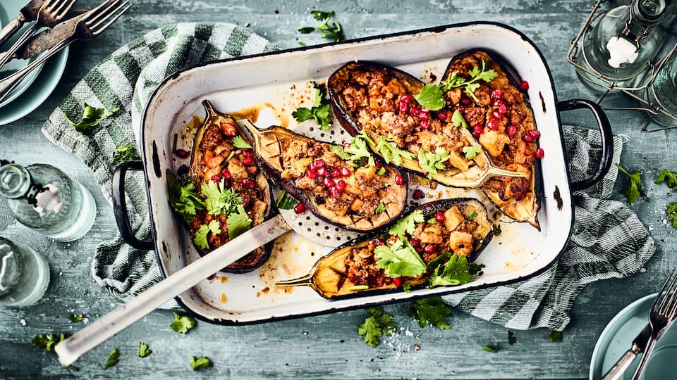 Dieses mediterrane Gericht aus dem Ofen ist in 70 Minuten auf dem Tisch: Probieren Sie unsere Aubergine mit einer pikanten Hackfleisch-Möhren-Füllung, dazu Büffelmozzarella und Granatapfelkerne!