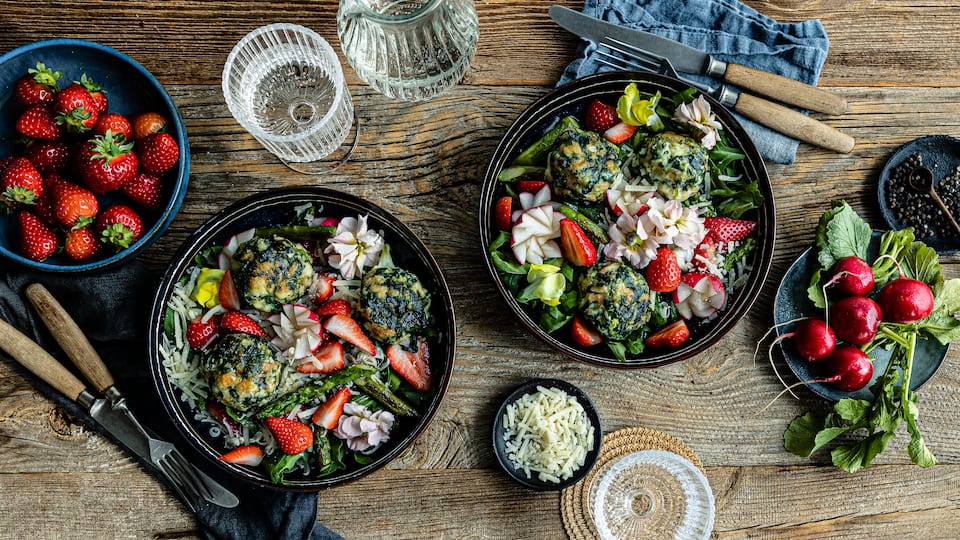 Jetzt gibt’s Frühling auf den Teller: Würzige Ricotta-Spinat-Knödel mit Frühlingssalat aus Spargel, Rucola, Erdbeeren und Parmesan.