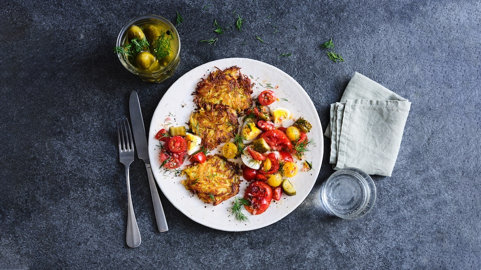 Knusprige Kartoffelrösti mit einem leckeren Salat aus Tomaten und Gewürzgurken: Alles was Sie brauchen sind 30 Minuten und 5 Zutaten sowie ein paar Kleinigkeiten aus dem Vorratsschrank. 