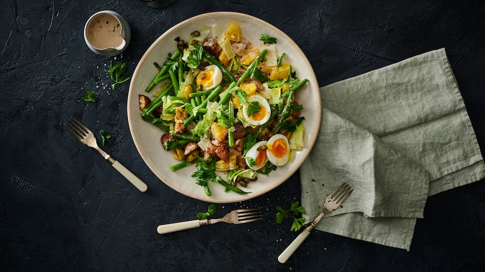 Kartoffelsalat geht immer! Wir servieren den Klassiker mit grünen Bohnen, Oliven, Thunfisch und gekochten Eiern.
